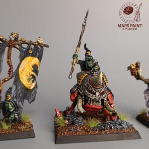 Puede incluir: Figuras de fantasía en miniatura, que incluyen una pancarta con caras de luna amarillas sobre banderas negras, un jinete sobre una criatura roja y gris, y una figura con humo púrpura. Las figuras están sobre bases cuadradas.