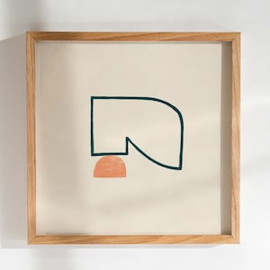 以下が含まれることがあります： 額装された抽象芸術プリント。クリーム色の背景に、ティール色の幾何学模様とピーチ色の半円が描かれています。このプリントは天然木のフレームに入っており、ミニマリストな美学を演出しています。フレームのサイズは約30cm x 30cmです。