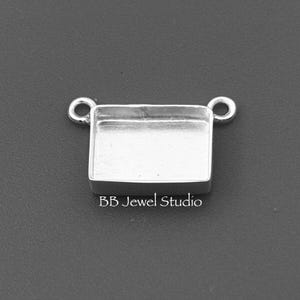 May include: A silver-coloured rectangular jewellery finding with two loop connectors. The base is a shallow tray. The text "BB Jewel Studio" is printed on the bottom.