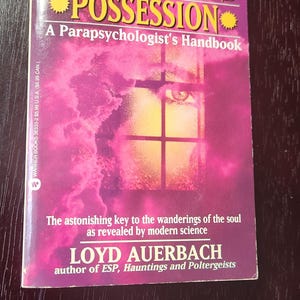 May include: A pink and purple book cover with the title "Reincarnation, Channeling and Possession: A Parapsychologist's Handbook" by Loyd Auerbach, author of "ESP, Hauntings and Poltergeists".