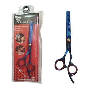 May include: Blue and purple thinning shears with a gold-toned tension screw, featuring a serrated blade and finger rest. The scissors are displayed both outside and inside a clear plastic retail package labeled Verstyle with red accents.