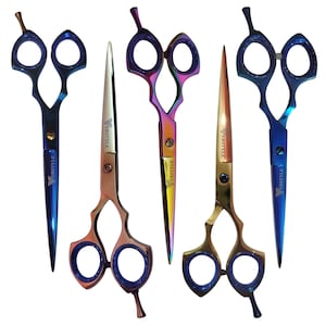 May include: Five professional hair cutting shears with finger rests and finger rings. The scissors feature iridescent, blue, and gold metallic finishes. Each blade is engraved with the brand name VERSTYLE. The designs include varying handle shapes.
