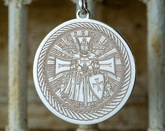 May include: A silver pendant necklace featuring a detailed circular medallion. The medallion showcases an engraved design of a figure with a cross, shield, and intricate border. The pendant hangs from a delicate silver chain, creating a classic and elegant accessory.