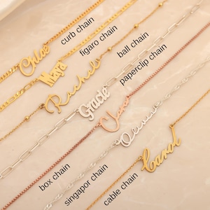 May include: A collection of gold and silver name necklaces with various chain styles, including curb, figaro, ball, paperclip, box, singapor, and cable chains. Each necklace features a different name in a cursive font.