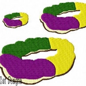 May include: Three Mardi Gras King Cake donuts, one large, one medium, and one small. The donuts are decorated with purple, green, and gold icing.