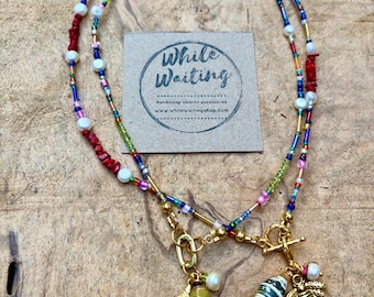 Friendship necklace with charms- coral, peridot, freshwater pearl, gold, bee & fish charm
