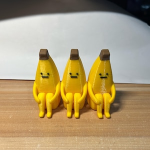 Banana sorridente impressa em 3D, brinquedo decorativo para mesa que abraça.