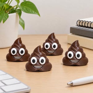 May include: Four small, brown, swirl-shaped figurines with white and black googly eyes and a wide, smiling mouth. Each figurine has a smooth, glossy texture and a rounded base, arranged in a group on a flat surface.