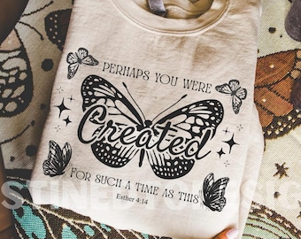 Puede incluir: Sudadera crema con un gran diseño de mariposa en blanco y negro. El texto dice "Perhaps You Were Created For Such A Time As This" y el versículo bíblico Ester 4:14. También hay gráficos adicionales de mariposas y estrellas.