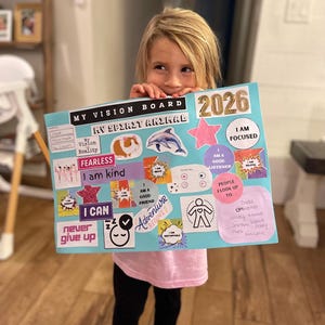 Puede incluir: Un tablero de visi&oacute;n con el texto "MY VISION BOARD" y "2026". El tablero presenta varias im&aacute;genes y frases, incluyendo un conejillo de indias, un delf&iacute;n y las palabras "FEARLESS" y "I CAN". El tablero es sostenido por una persona.