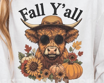 May include: White long-sleeve shirt with a graphic of a Highland cow wearing sunglasses and a hat, with the text "Fall Y'all". The cow is surrounded by pumpkins, sunflowers, and fall leaves.