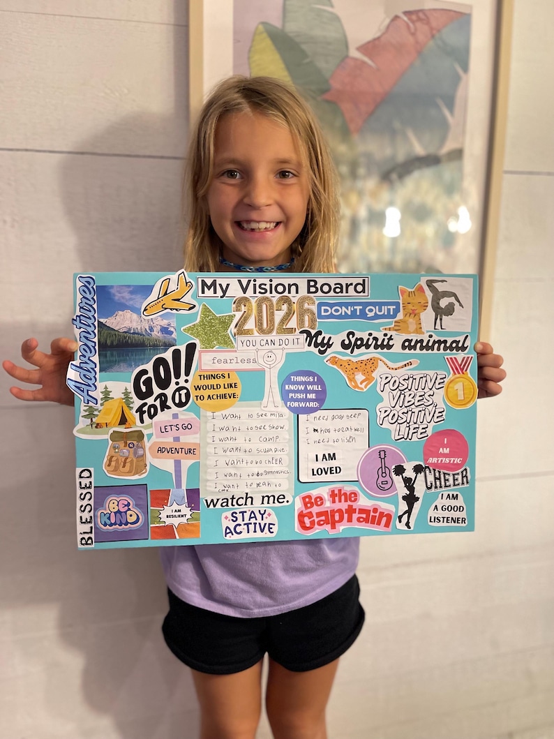 Puede incluir: Una ni&ntilde;a sostiene un tablero de visi&oacute;n con las palabras "My Vision Board 2026" y varias pegatinas. El tablero incluye frases como "Go for it", "Adventure" y "Positive Vibes, Positive Life."