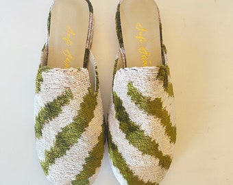 May include: A pair of green and white patterned velvet slippers with the text "Off Duty" written on the inside of each slipper.