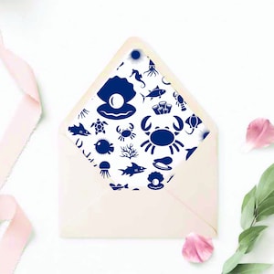 May include: A white envelope with a blue and white sea life pattern on the front. The pattern includes a variety of sea creatures, such as fish, crabs, seahorses, and jellyfish.