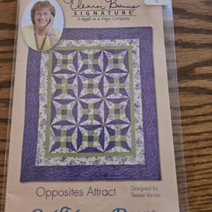 May include: A quilt pattern package featuring a finished quilt design with purple and green geometric shapes. The package includes a photo of Eleanor Burns and the text "Opposites Attract" and "Quilt in a Day".