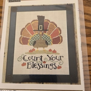 May include: A white ceramic mug with a black handle and the text "But First, Coffee" in a black, handwritten-style font. The mug is on a white surface.