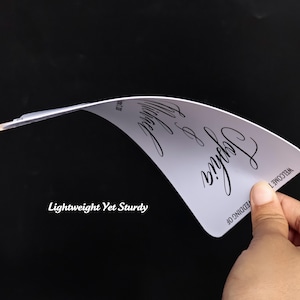 May include: A flexible, white rectangular sign with rounded corners featuring black cursive text that reads "Welcome to the wedding of Sophia & Michael" and "June 17, 2026". The text "Lightweight Yet Sturdy" is printed in the lower left corner.
