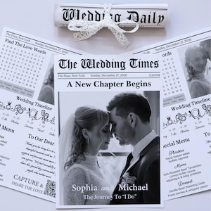 May include: A wedding newspaper program titled The Wedding Times featuring a black and white photograph of a couple, Sophia and Michael, with the text A New Chapter Begins, a wedding timeline, a menu, and a rolled Wedding Daily scroll tied with lace.