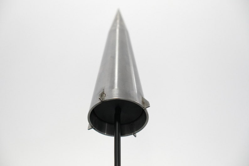 May include: A silver metal cone with a black base and a pointed tip. The cone has a series of small metal tabs around the base.
