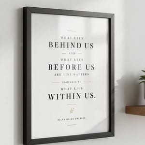 May include: A framed print with a black border, displaying the quote "WHAT LIES BEHIND US AND WHAT LIES BEFORE US ARE TINY MATTERS COMPARED TO WHAT LIES WITHIN US." by Ralph Waldo Emerson. The text is in black on a white background.