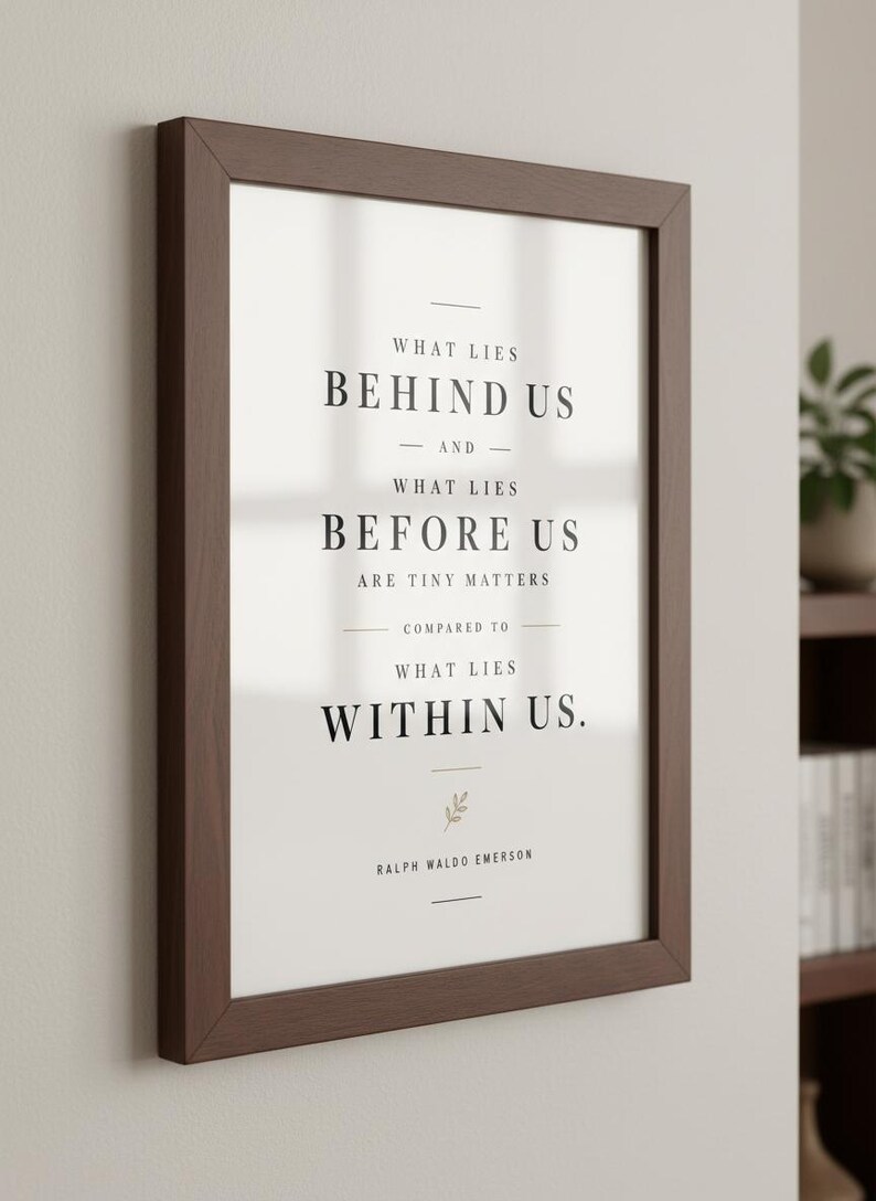 May include: A framed print with a dark brown wooden frame. The print features the quote "What lies behind us and what lies before us are tiny matters compared to what lies within us." by Ralph Waldo Emerson, in black text on a white background.