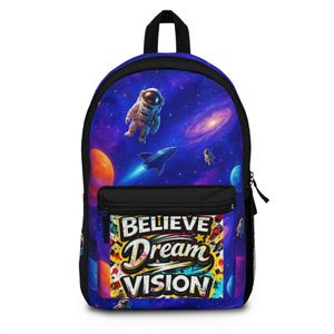 May include: A backpack featuring a vibrant space-themed print with astronauts, a rocket, and planets against a purple and blue nebula background. The front pocket displays the text "BELIEVE Dream VISION" in a bold, stylized, multi-colored font.