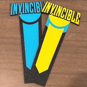 May include: A white ceramic mug with a black handle and the text "But First, Coffee" in a bold, black font. The mug is set against a blurred background, suggesting a cozy setting.