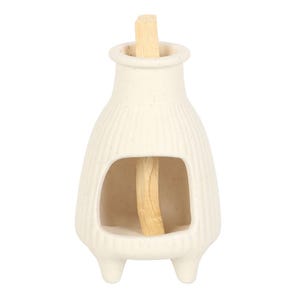 May include: Cream-colored ceramic incense holder with a vertical opening and three small feet. A light-colored wooden incense stick is placed inside the holder. The holder has a textured, ribbed design.