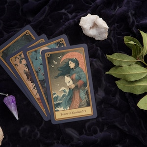 Peut inclure: Jeu de cartes de tarot avec des illustrations d'une femme, d'oiseaux et de vagues. Un pendule en cristal violet et des cristaux blancs sont dispos&eacute;s sur un fond sombre et textur&eacute;. Les cartes ont une bordure bleue.