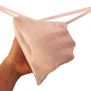 May include: White mesh lingerie with thin straps. The mesh is delicate and has a fine knit pattern.