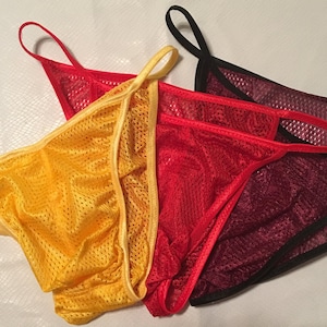 Pode incluir: Três pares de roupa interior de malha em amarelo, vermelho e bordô.