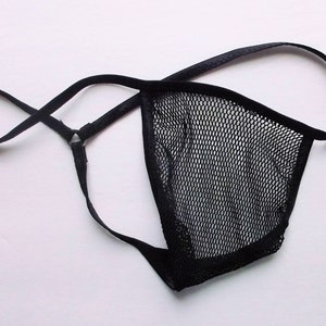 May include: Black mesh lingerie with adjustable straps. The straps are made of a thin, black fabric and have a metal ring at the center.