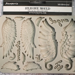 Może przedstawiać: Silikonowa forma w jasnoszarym kolorze z motywami skrzydeł anioła, piór i napisem "dream" w kursywie. Forma ma wymiary 14,8 x 21 cm (5,83 x 8,27 cala). Produkt firmy Stamperia.