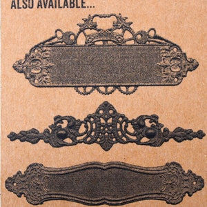 May include: Three decorative metal plaques with ornate designs. The top plaque has a scroll-like design with a blank space in the center. The middle plaque has a more intricate design with a blank space in the center. The bottom plaque has a simple, rectangular design with a blank space in the center. The text "ALSO AVAILABLE..." is printed above the plaques.
