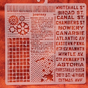 May include: A cream-colored stencil with the word "journey" and definitions, along with a list of street names. Decorative elements include gears and a grid pattern. The stencil is designed for crafting and DIY projects.