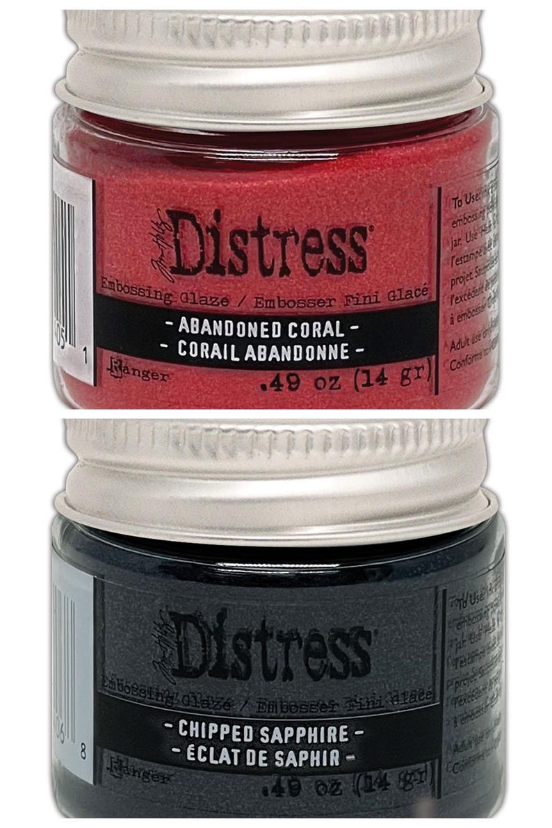 Op de afbeelding: Twee kleine potjes Distress Embossing Glaze. De bovenste pot is rood en heeft het label "Abandoned Coral - Corail Abandonn&eacute; - 0,49 oz (14 g)". De onderste pot is donkerblauw en heeft het label "Chipped Sapphire - &Eacute;clat de Saphir - 0,49 oz (14 g)".