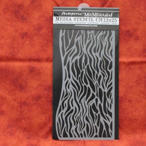 May include: Black and gray stencil with a wood grain pattern. The stencil is 12 inches by 25 inches and is made of a durable plastic. It is labeled "MixMediaArt" and "Stamperia".