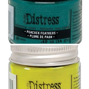 Op de afbeelding: Twee kleine potjes Distress Embossing Glaze. De bovenste pot is tealgroen en heeft het label "Peacock Feathers - Plume de Paon". De onderste pot is geel en heeft het label "Squeezed Lemonade - Limonade Press&eacute;e". Beide potjes zijn 0,49 ounce (14 gram).
