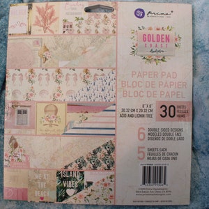 May include: A paper pad with 30 sheets of double-sided patterned paper. The paper pad is 8x8 inches and acid and lignin free. The paper features a coastal theme with images of seashells, seahorses, and a hot air balloon. The paper pad is titled "Golden Coast" and has a pink and blue color scheme.
