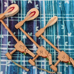 Puede incluir: Tres herramientas de afinación de martillo de piano de madera con cabezales de fieltro. Las herramientas están etiquetadas con los números 19, 34 y 75.