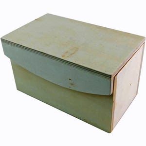 Könnte beinhalten: Eine einfache Holzkiste mit einem Scharnierdeckel. Die Kiste ist aus hellem Holz gefertigt und hat eine glatte Oberfläche.