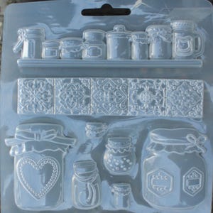 May include: A clear plastic mold with various shapes of jars, a shelf, and tiles. The mold is designed for making decorative items.