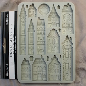 以下が含まれることがあります： 14種類の異なるデザインの家と時計がついた灰色のシリコンモールド。モールドのサイズは14.8 x 21 cm / 5.83 x 8.27インチです。