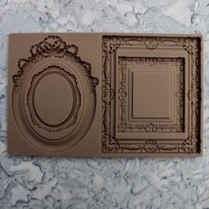 Könnte beinhalten: Eine braune Silikonform mit verzierten Rahmenmotiven. Die Form enthält ovale und rechteckige Rahmenformen mit detaillierten Blumen- und Scrollmustern. Der Text "ITEM NO: 679422 ORNATE LEGACY" und "WWW.REDESIGNWITHPRIMA.COM" sind sichtbar.