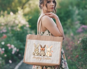 Może przedstawiać: Beżowa torba typu tote z białym panelem z trzema wzorami króliczków wielkanocnych. Króliczki mają różne wzory i kolory. Słowa "Happy Easter" są napisane złotym pismem poniżej. Torba ma uchwyty ze sznurka.