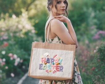 Może przedstawiać: Beżowa torba typu tote z białym przednim panelem z napisem "Happy Easter" w kolorowym haftem, wraz z motywami wielkanocnymi. Torba ma sznurkowe uchwyty i naturalny jutowy korpus.