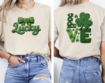 Może przedstawiać: Beżowa koszulka z zieloną dzianinową kokardą i napisem "Lucky" w zielonym kolorze. Tył koszulki zdobi napis "LOVE" z motywem koniczyny, wszystko w zielonym stylu dzianinowym. Koszulka jest połączona z niebieskimi dżinsami.