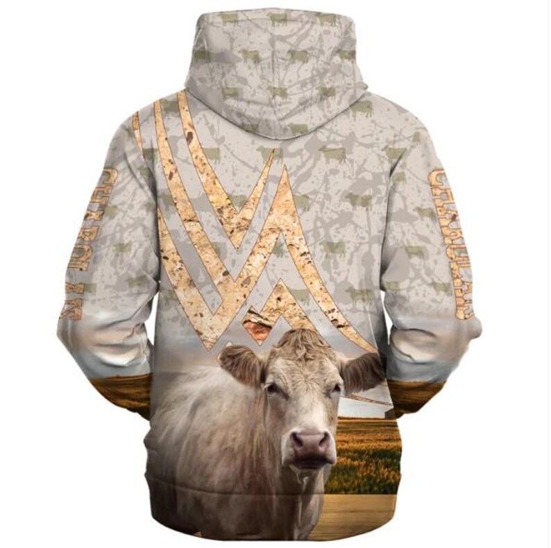 May include: A hooded sweatshirt featuring a light beige background with a repeating cow silhouette pattern. The back displays a large, textured, tan-colored geometric design above a realistic image of a white cow in a field. The word CHAROLAIS is printed vertically on both sleeves.