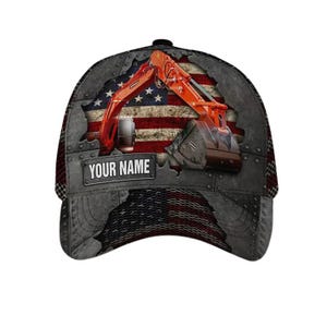 Könnte beinhalten: Eine Baseballkappe mit einer Grafik eines orangefarbenen Baggers vor dem Hintergrund einer abgenutzten amerikanischen Flagge. Das Design umfasst ein metallisch wirkendes Paneel mit Nieten und ein rechteckiges Schild mit dem Text YOUR NAME.