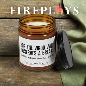 May include: A brown glass jar candle with a black lid, featuring the text "FOR THE VIRGO WHO DESERVES A BREAK." The candle has a white label and a lit wick. The brand name "FIREPLOYS" is displayed at the top.